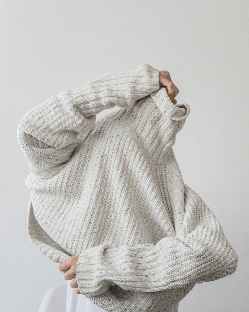 Close view of an oversized cream ribbed sweater